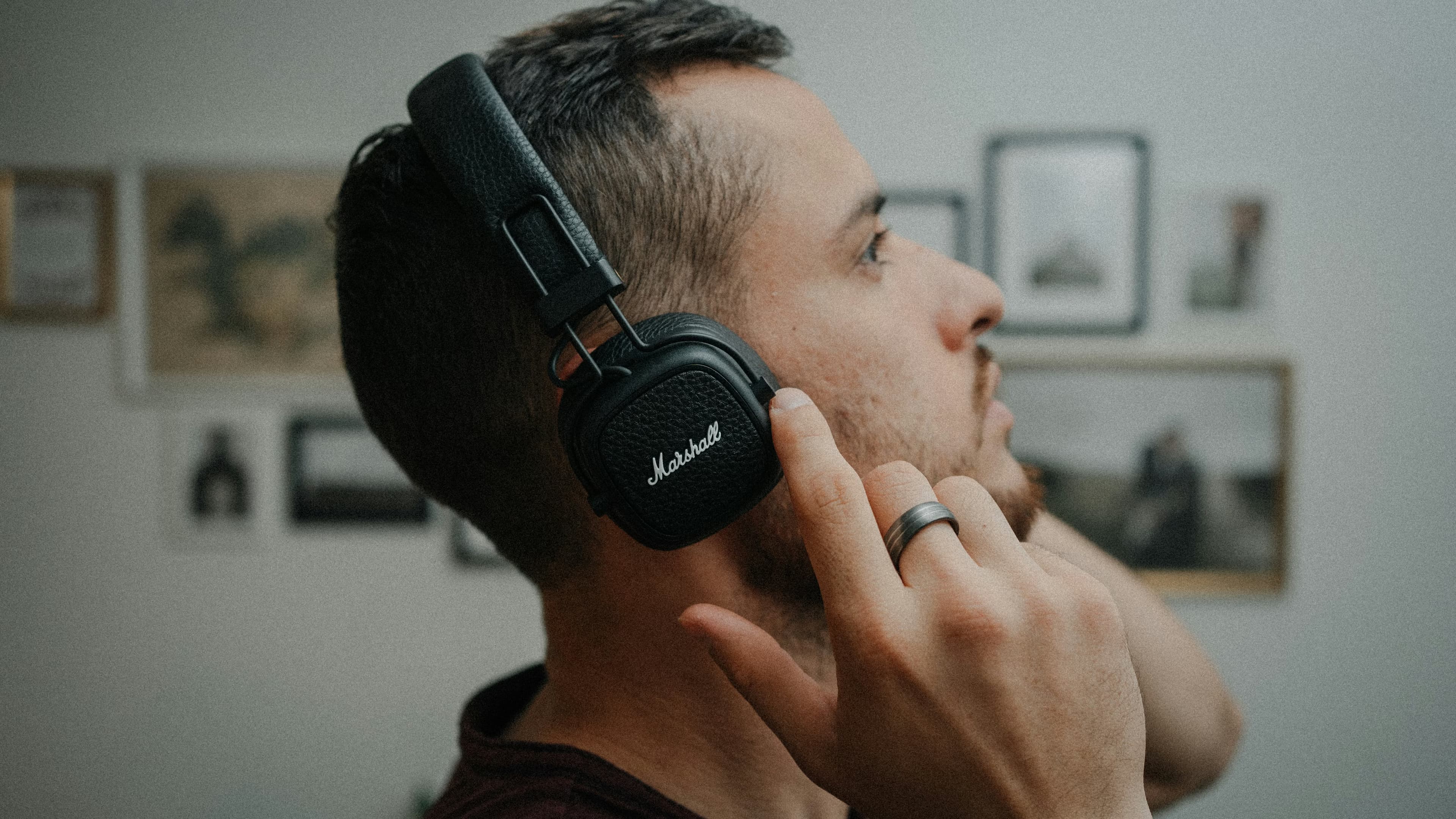 Person wearing headphones listening closely to audio